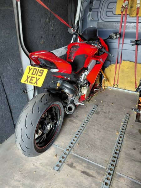Red Ducati secured inside a van for specialist motorcycle delivery